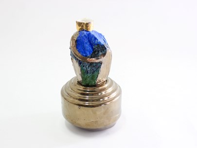 A trophy-like object in a gold-coloured metal with something blue at the top