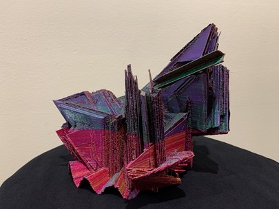 A sculpture made of sheets of coloured cardboard cut into geometric shapes