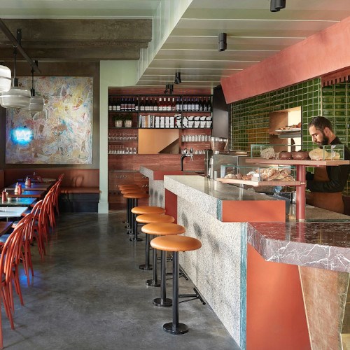 Photo of the interior of the cafe with the bar on the right and tables on the left.