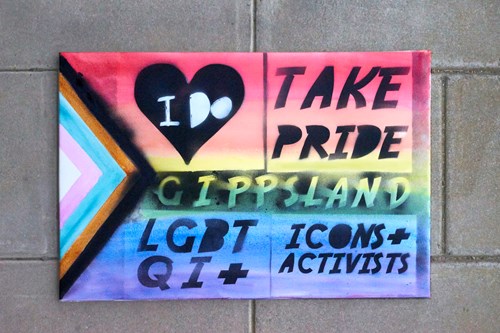 Bricks with a pride flag displaying text 'TAKE PRIDE GIPPSLAND: LGBTQU+ icons + activists' 